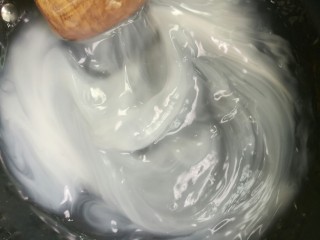 4、刮凉粉,水开后，将淀粉水重新搅起，要无沉淀，边倒边搅拌。