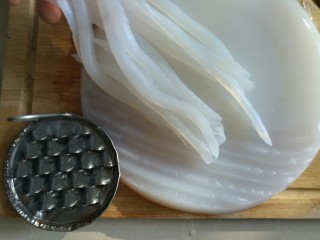 11、刮凉粉,凉粉到在砧板上，用专用的凉粉刮子将凉粉刮成10cm左右的细条。