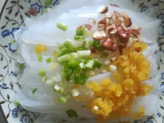 12、刮凉粉,将凉粉摆在盘子里，再撒上甜萝卜碎，葱花，花生碎。