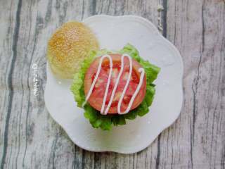 9、田园猪肉堡,将面包横切为二,上下两片分别涂抹沙拉酱。依次放上生菜、番茄片、肉饼,再盖上一片生菜,最后把顶上的面包片扣上。