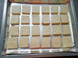 2、香烤老豆腐,烤盘里铺上锡纸，将准备好的豆腐块摆在烤盘里。