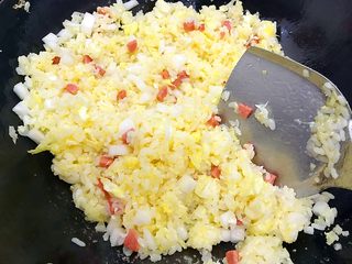 16、炒饭秀～黄金混蛋炒饭,继续翻炒，这一步需要一点耐心，由于全程都是用小火，所以制作过程有点长，这一步需要五六分钟的样子，直至米饭不再结块而是颗粒分明