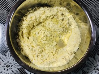 4、玉米窝窝头,倒入面粉中。然后每次少量加入温水，和成面团