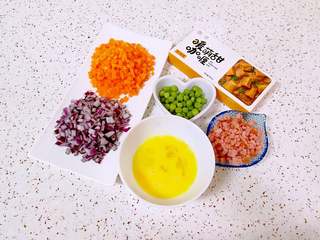 1、咖喱炒饭,准备好食材，青豆提前焯熟，洋葱胡萝卜洗干净切成小丁，火腿肠切成小丁，鸡蛋打散。
