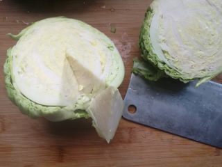 2、素味炒饼,洋白菜一切两半,去掉根,一片一片剥开叶子清洗干净。