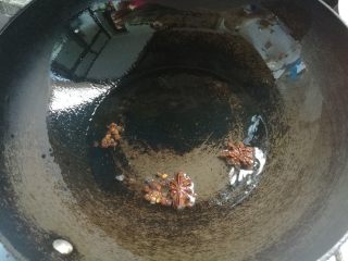 4、素味炒饼,锅坐火上烧热后,放入花椒粒,大料2个。