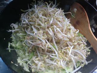 7、素味炒饼,放洋白菜丝、放入红萝卜丝煸炒至八分熟。