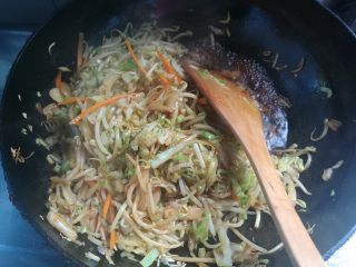 8、素味炒饼,倒入生抽、老抽翻炒均匀,蔬菜炒制会出水,如果水太多倒出一些,留一小部分。