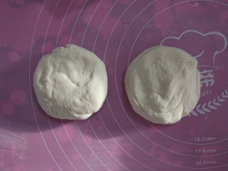 2、家常烙饼,取出面团，揉面垫撒少许手粉，不需要揉制面团，只需要稍微整形，分成两份。整圆，按扁。