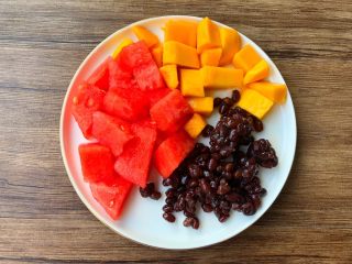 4、黑凉粉水果捞,西瓜去皮切成小块,芒果去皮去核切成小块,蜜红豆准备好。