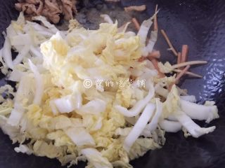 9、三丝炒面,等肉丝差不多熟了的时候，把它扒拉到一边，随后放入胡萝卜丝和娃娃菜，翻炒。