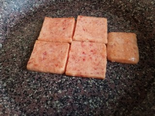 12、耳光炒饭,取不粘锅倒入少许油，放入午餐肉，煎至两面焦黄盛出备用