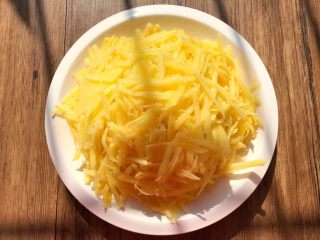 1、土豆煎饼,土豆挂掉外皮，清洗干净，用工具刨成丝，装入盘里待用，千万不要再清洗了。