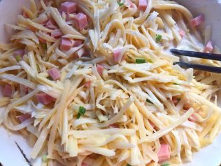 6、土豆煎饼,加入土豆丝、香肠丁、葱花搅拌均匀即可。