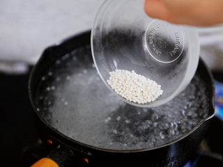 2、可以吸着喝的杨枝甘露,锅中烧开水,将西米以画圈的方式慢慢的倒入,水的用量最好放多一点,最少也是西米的10倍,这样才不会煮干