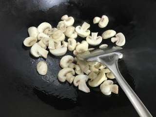 6、绣花锦蘑菇汤年糕,放入蘑菇翻炒。