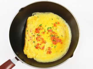 16、番茄金蛋烧,接着倒入剩下的鸡蛋液，倒在鸡蛋卷的另一头，小火加热。