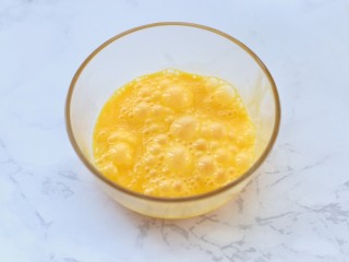 4、蔬菜培根蛋炒饭,鸡蛋磕入碗中搅打均匀