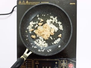 8、芝士片烤吞拿鱼饭团,倒入吞拿鱼翻炒几下,按个人口味加入适量盐,糖等调味,酱油可选。