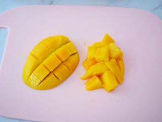 5、水果冷泡茶,芒果去掉中间的核,果肉部分打花刀,用手指顶住果皮部分往上翻,这样果肉就被顶起来了,再将芒果肉用小刀全部切下来备用