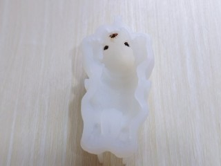 9、高颜值沙皮狗冰激凌,首先隔水融化少许巧克力，装入裱花袋，挤出眼睛与鼻子，爪子也可以涂上，我嫌麻烦，爪子没有涂。