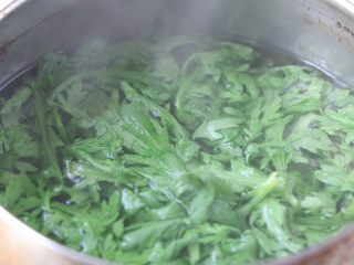 2、茼蒿早餐饼,茼蒿叶放入清水里放盐浸泡几分钟，冲洗干净后，开水焯水一遍；