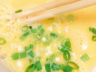3、香肠炒饭,将一半的葱花放入鸡蛋液中搅拌