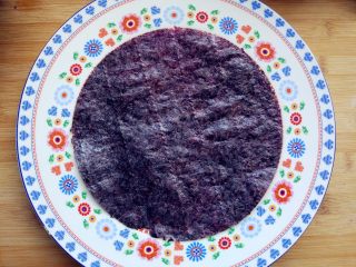 8、“属”于你—卡通儿童餐,将用来做寿司的烤紫菜放在砧板上,将一个大小合适的盘子倒扣在上面,用小刻刀沿四周划一圈,去掉多余的部分后,铺在大盘内