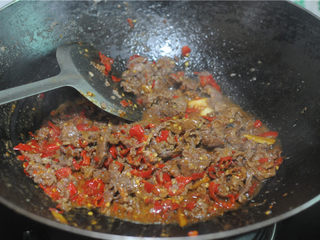 9、剁椒牛肉,此时改用大火,将事先炒好的牛肉加入,倒入料酒进行翻炒,让剁椒、蒜、葱炒的香味充分渗入牛肉中