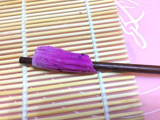 15、炒果蔬空心面,取一小片,放到寿司帘上,用筷子压在边,往上卷起,