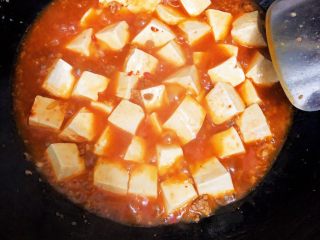 15、麻婆豆腐,待锅中沸腾后，倒入调好的淀粉水进行收汁收汁过程轻轻晃锅，避免粘锅变糊。注意：豆瓣酱是咸的，加入少许盐调味就行了，不宜过多