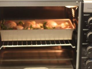 7、【蒜香番茄烤鸡腿】,把烤盘放进烤箱中层，200度烤烤60分钟