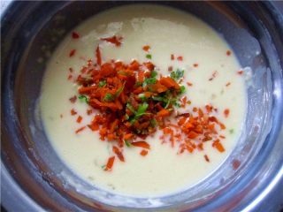 7、胡萝卜鸡蛋饼,将切碎的胡萝卜和葱碎放入蛋糊中