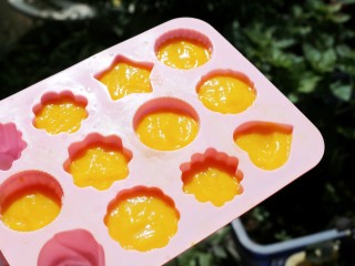 6、百变水果 芒果冰格,将打出来的芒果牛奶汁倒入准备好的冰格模具中，如果要做分层效果，可以将剩余的牛奶倒入一部分，再倒入芒果汁，随自己喜欢