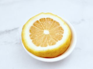 5、橘子蔓越莓蜂蜜冰饮,把柠檬洗净后用刀切成片。
