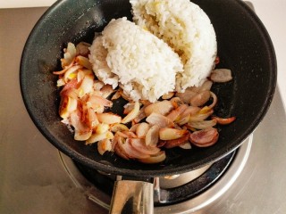 4、什锦咖喱焗饭,留底油。放入切好的洋葱炒出香味，炒至金黄色时，加入米饭。继续翻炒。