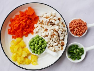 2、色彩缤纷的菠萝炒饭,香菇,胡萝卜,火腿,香葱切丁,豌豆剥粒。