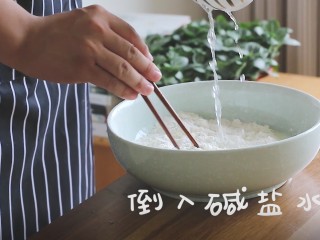 2、陕西油泼面,将盐碱水倒入面粉中，一边倒一边搅拌，注意用水量