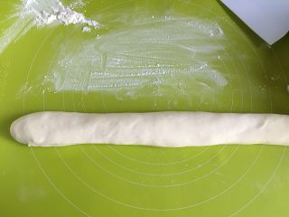 6、牛肉馅饼,20分钟以后取出面团，面板上撒适量面粉防粘，把面团揉成长条