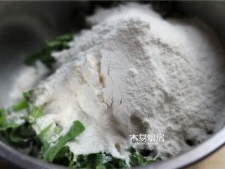 3、小白菜饼,倒入适量面粉，加少许水，搅拌均匀。