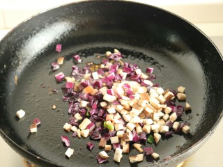 6、香菇酱五彩菠萝饭,放入香菇丁和紫甘蓝丁翻炒。