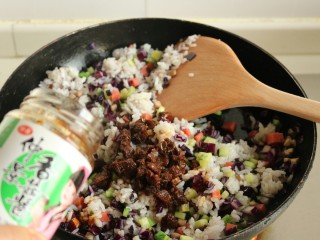 9、香菇酱五彩菠萝饭,加入两大勺香菇酱，继续翻炒均匀。