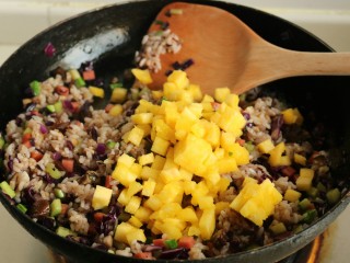 10、香菇酱五彩菠萝饭,加入菠萝丁翻炒均匀就可以关火。