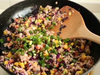 11、香菇酱五彩菠萝饭,加入小葱末，翻炒均匀。