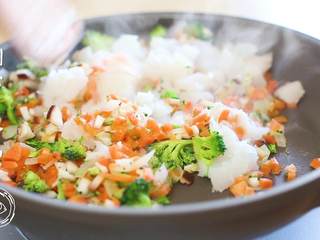 4、12m+鳕鱼软饭（宝宝辅食）,接下来放入之前切好的胡萝卜、西蓝花、香菇丁，翻炒半分钟之后，倒入鳕鱼，再翻炒两分钟~