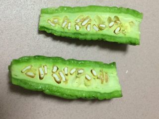 6、焖烧罐凉瓜黄豆排骨汤,凉瓜其实就是苦瓜，在粤菜里苦瓜叫凉瓜，取一小半切开一分为二，掏取苦瓜籽,边上的白色一层也要去掉，因为那一层白色膜去掉就不是那么苦了