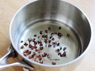 4、十味 多汁猪肉煎饺,再取一小锅,倒入植物油40克,加一小撮花椒,上火烧热。