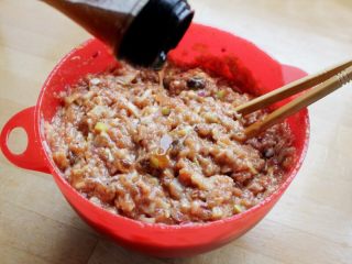 8、十味 多汁猪肉煎饺,最后试一下味道,根据实际情况加少量调料调整,再滴一些香油,大约10克,到此多汁猪肉饺子馅就拌好了。