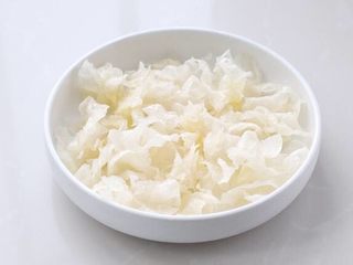 2、木瓜炖牛奶,将银耳提前五、六个小时泡发，剪掉根部撕成小片。