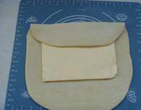 3、拿破仑酥,面团取出，擀成约裹入黄油是面片的2/3长度；面片上部的3/1折下来，盖住黄油的一半